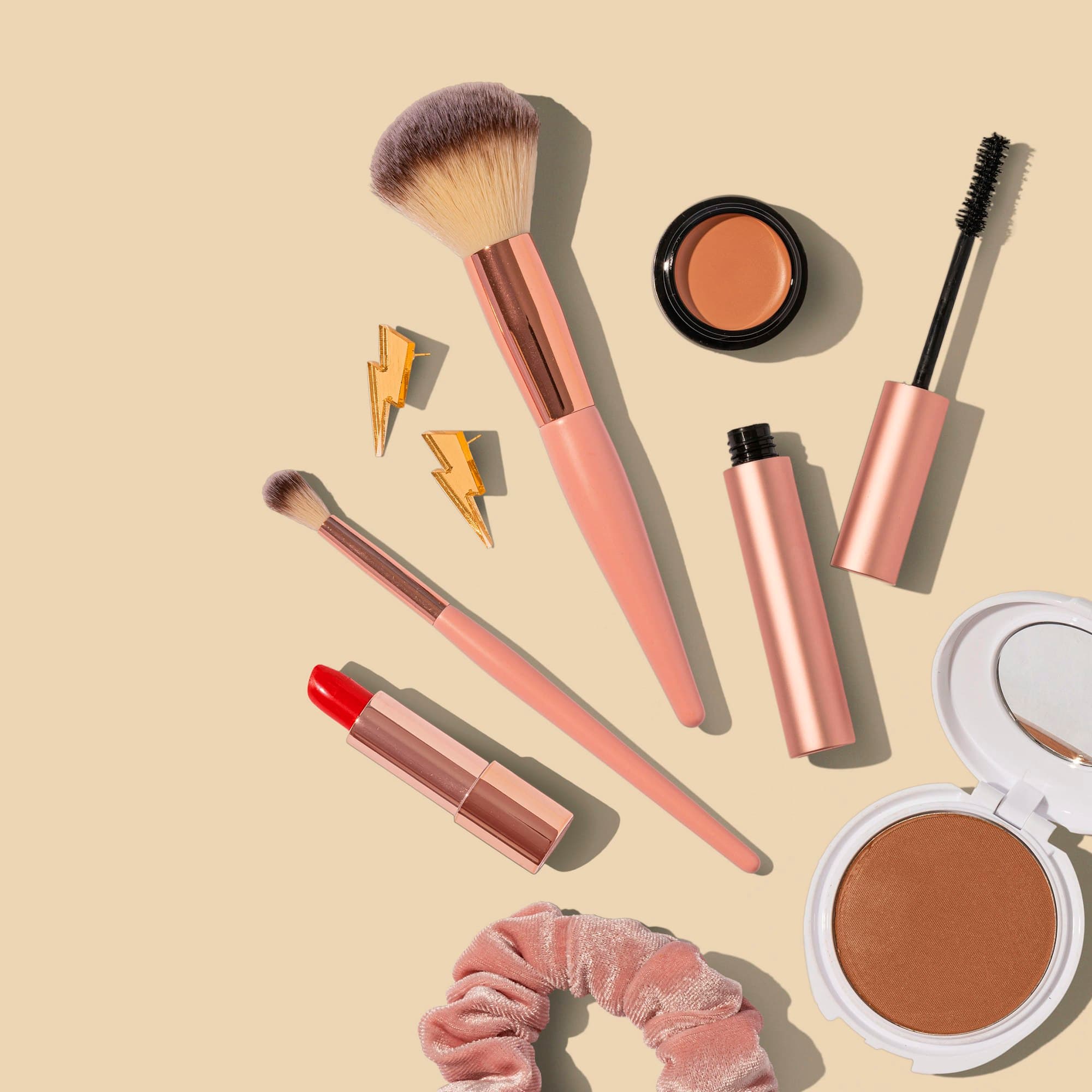 Maquillaje de uso diario: brochas, labial y polvos en tonos cálidos